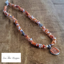 Load image into Gallery viewer, Spiny Oyster Necklace on wooden background, orange side.
