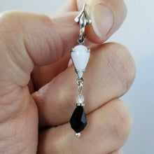 Load image into Gallery viewer, Vintage Milk Glass Crystal and Jet Swarovski Earrings held in hand.
