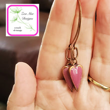 Load image into Gallery viewer, Antique copper dangle heart earrings held in hand.
