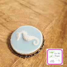 Load image into Gallery viewer, Blue Seahorse Convertible Brooch Pin  on wooden background.
