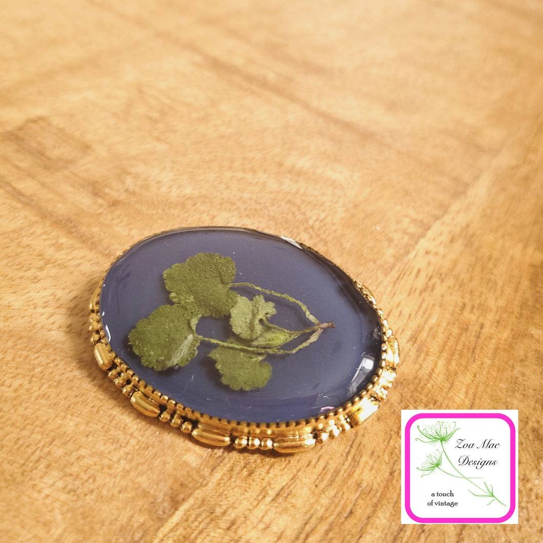  Navy with Leaves Convertible Brooch Pin on wooden background.