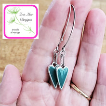 Load image into Gallery viewer, Antique Silver dangle heart earrings held in hand.
