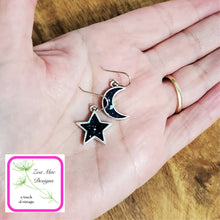 Load image into Gallery viewer, Moon and Star Earrings held in hand.
